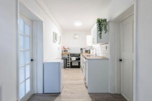 cocina con armarios blancos y nevera blanca en Contractors, Families, FREE PARKING, Central - Print Place by Prescott Apartments en Bristol