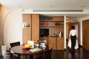 una persona de pie en una sala de estar con mesa de comedor en Best Western Premier BHR Treviso Hotel, en Quinto di Treviso