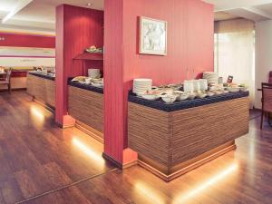 a buffet line in a restaurant with plates of food at Mercure Hotel Koeln Belfortstrasse in Cologne