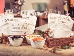 a table with baskets and bowls of food on it at Mercure Hotel Koeln Belfortstrasse in Cologne