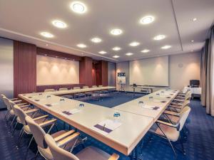 une grande salle de conférence avec une grande table et des chaises dans l'établissement Mercure Hotel München Airport Freising, à Freising