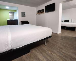 a bedroom with a large white bed with a flat screen tv at Motel 6-Columbus, GA - Downtown in Columbus
