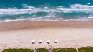 una vista aérea de una playa con sillas y el océano en Vivá Barra Hotel Pousada, en Barra de São Miguel
