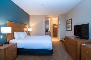a hotel room with a bed and a flat screen tv at Sandman Hotel and Suites Squamish in Squamish