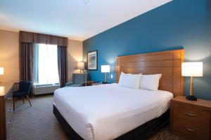 a hotel room with a large bed and a blue wall at Sandman Hotel and Suites Squamish in Squamish