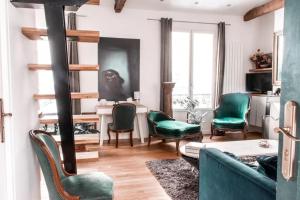 - un salon avec des fauteuils verts et un canapé dans l'établissement Appartement type loft - 40m² Marais, à Paris