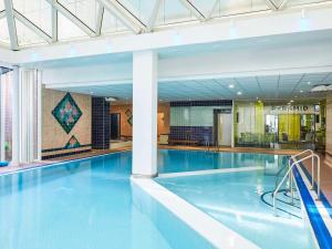een groot zwembad met blauw water in een gebouw bij Mercure St Helens in Saint Helens