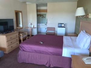 a hotel room with a large bed and a television at Centralia Inn in Centralia