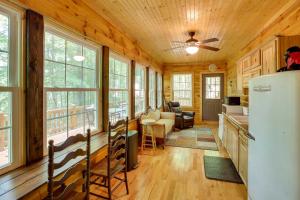 a kitchen and living room in a log cabin at Byrdstown Cabin - with Fire Pit, Near Marina and Lake! in Frogue