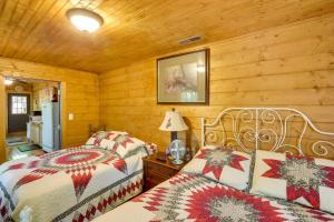 a bedroom with two beds in a log cabin at Byrdstown Cabin - with Fire Pit, Near Marina and Lake! in Frogue