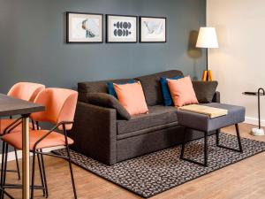 a living room with a couch and a table and chairs at Aparthotel Adagio London Sutton Point in Sutton