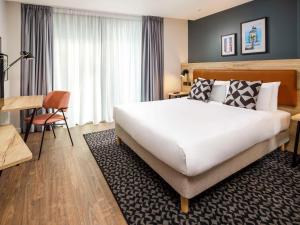 um quarto de hotel com uma cama grande e uma secretária em Aparthotel Adagio London Sutton Point em Sutton