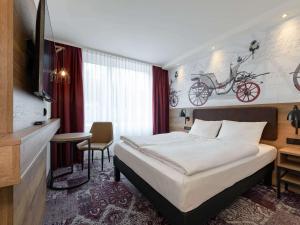 a hotel room with a bed and a bike painting on the wall at ibis Styles Coburg in Coburg