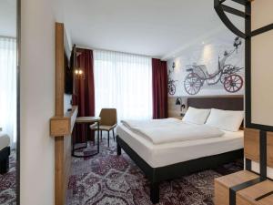 a bedroom with a bed and a room with a bike on the wall at ibis Styles Coburg in Coburg