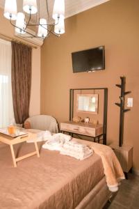 um quarto com uma cama, uma mesa e um espelho em The 50/50 Luxury Apartments em Sidari
