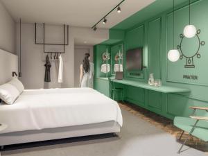 um quarto com uma cama branca e uma parede verde em ibis Styles Graz Messe em Graz