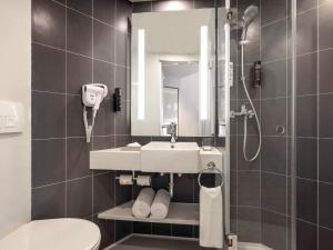 a bathroom with a sink and a shower and a toilet at ibis Mumbai Vikhroli - An Accor Brand in Mumbai