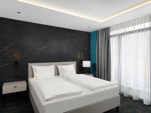 sypialnia z białym łóżkiem i czarną ścianą w obiekcie Mercure Tokaj Center w Tokaju