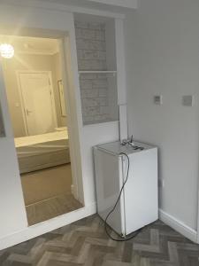 a white refrigerator in a room with a bedroom at Edgware Rooms in Stone Grove