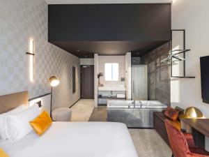 a bedroom with a large bed and a bathroom at Mercure Namur Hotel in Namur