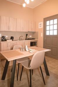 a kitchen with a wooden table and two chairs at The 50/50 Luxury Apartments in Sidari