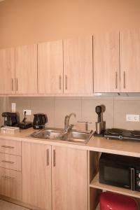 a kitchen with wooden cabinets and a sink at The 50/50 Luxury Apartments in Sidari