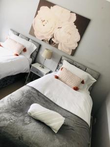 a bedroom with two beds with flowers on the wall at Modern 3 bed house 2 parking spaces contractors welcome in Stevenage