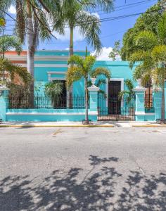 a blue building with palm trees in front of it at Casa Dos Lirios Hotel Boutique in Mérida