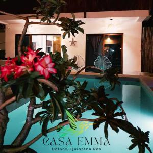a plant with red flowers in front of a house at Casa Emma fantástica con acceso a beach club ! in Holbox Island