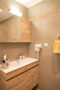 a bathroom with a sink and a shower at The 50/50 Luxury Apartments in Sidari