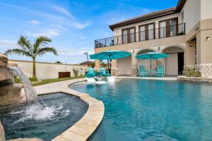 a swimming pool with a fountain in front of a house at Paradise Villa: 2 blocks from beach, private pool in South Padre Island