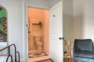 a bedroom with a bathroom with a toilet and a chair at Sugar's INN Room #2 in Galveston