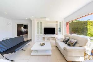 a living room with a couch and a tv at Ohana Luxury Villa with Heated Pool in Málaga