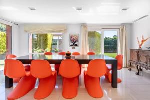 comedor con mesa y sillas naranjas en Ohana Luxury Villa with Heated Pool, en Málaga