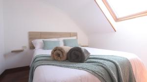 a bedroom with a bed with towels on it at Ático Laxe Grande in A Guarda