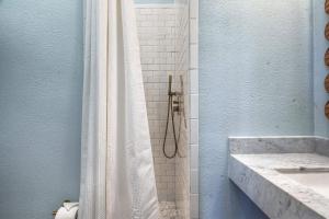 a bathroom with a shower with a white shower curtain at Sugar's INN Room #1 in Galveston