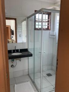a bathroom with a glass shower and a sink at Ipê Suites Juquehy in Juquei