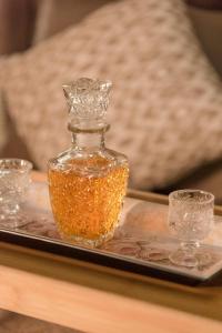 a glass bottle on a tray with two glasses at The 50/50 Luxury Apartments in Sidari