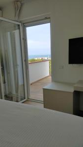 a bedroom with a bed and a sliding glass door at A.Mare in Stintino