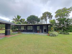 uma casa preta com um quintal em frente em Hospedaje Finca Agroturistica Doña Rufa em Río Sereno