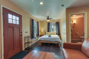 a bedroom with a bed and a couch and a door at Cozy Coeur dAlene Studio, Walk to Downtown and Lake in Coeur d'Alene