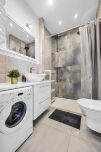 a bathroom with a washing machine and a sink at Studio Groszowicka AC SWPS in Warsaw