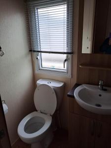 a small bathroom with a toilet and a sink at Sunblast in Cockwood