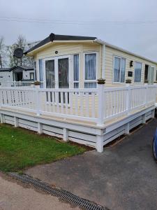 a house with a white fence and a porch at Sunblast- Dawlish Warren in Cockwood
