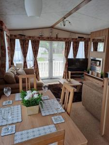 a living room with a table with wine glasses at Sunblast- Dawlish Warren in Cockwood