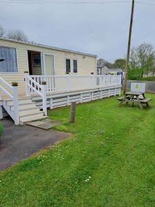 a house with a white porch and a picnic table at Sunblast- Dawlish Warren in Cockwood