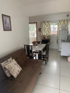 sala de estar y cocina con sofá y mesa en Aconchego do Vale, en Blumenau