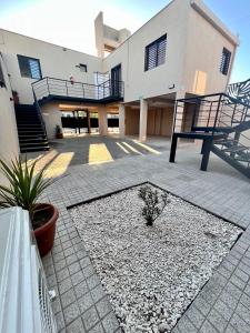 un edificio con un patio con un banco delante de él en Lumiere apartments 5- Departamento en complejo residencial en El Challao