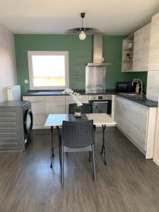 a kitchen with a table and some chairs and a stove at Place verte 2302 in Lille