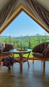 a living room with a table and two couches at Jagodowe Domki in Ciche